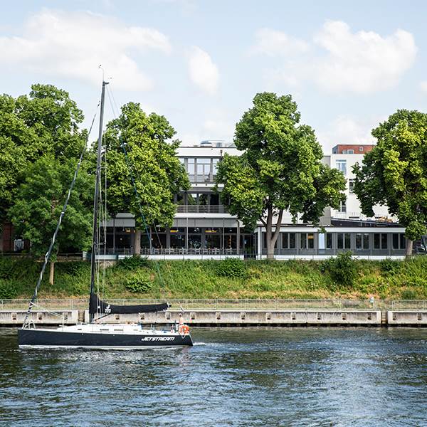 The hotel is located right next to a river at the waterfront surrounded by greenery.